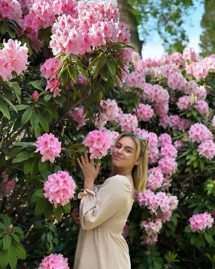 Shannah Lindh showcasing floral beauty and fashion, surrounded by vibrant flowers | Fashion Blogge