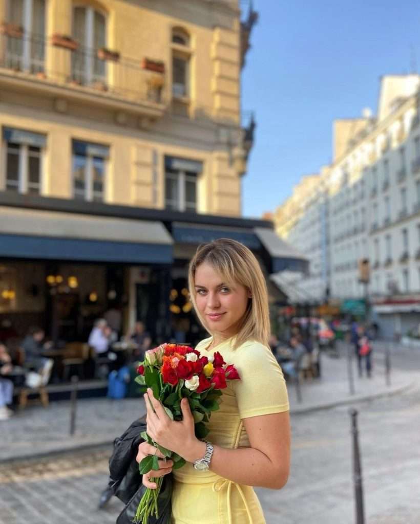 Shannah Lindh experiencing a sunny Parisian day surrounded by roses, capturing the charm of Paris | Travel Blogger